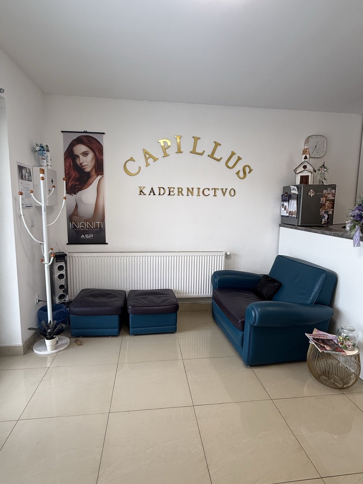 Capillus kaderníctvo — recepcia a čakáreň so zlatým logom CAPILLUS na stene